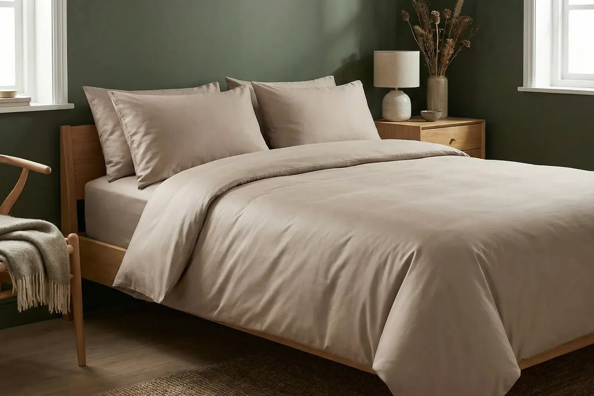 Opgemaakt bed met een taupe katoensatijn dekbedovertrekset