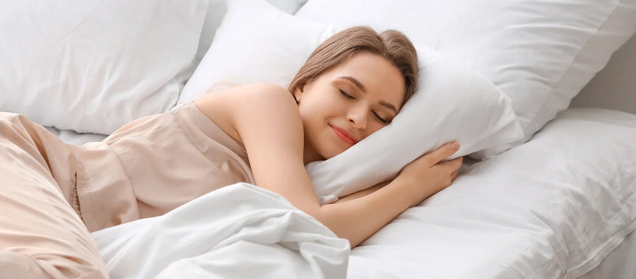 Vrouw slaapt ontspannen in een bed met wit beddengoed