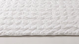Detailopname van de percal katoenen tijk en het golfstiksel van het Tencel zomerdekbed AeroFresh